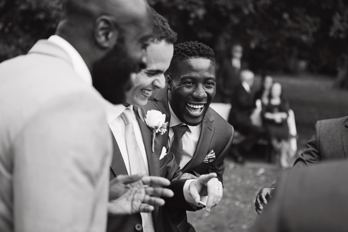 The groom shares a joke with his friends at his wedding